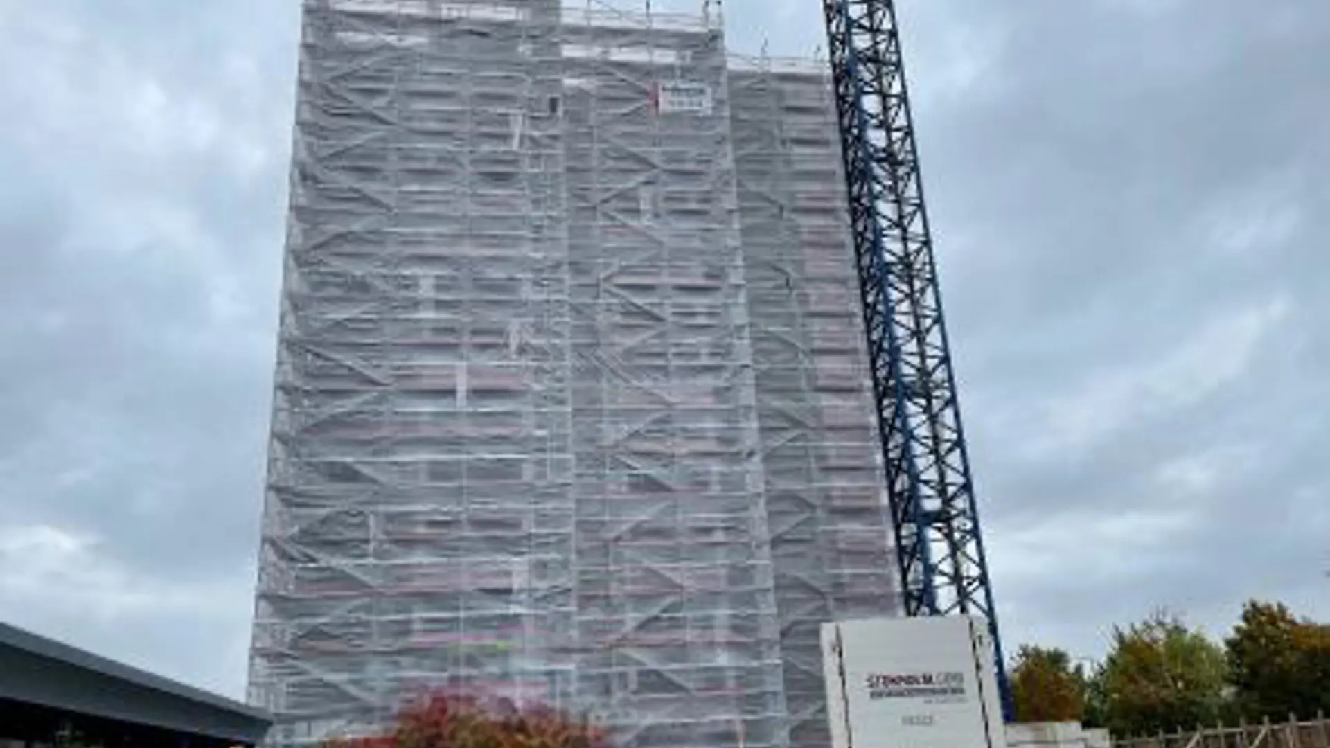 Højhus indpakket i stillads og armeret plast